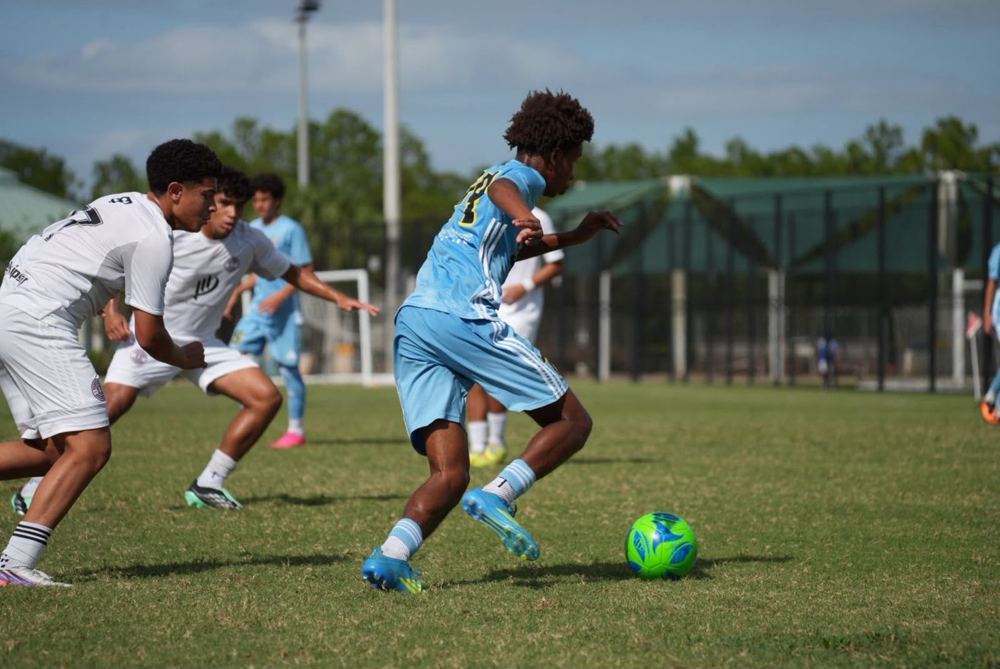 Chaz L. Grey dribbling between two defenders