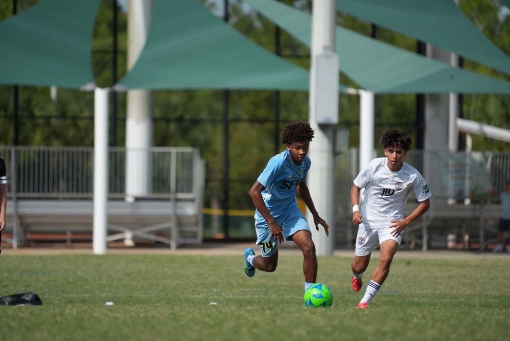 Chaz L. Grey driving forward with the ball as a defender closes in