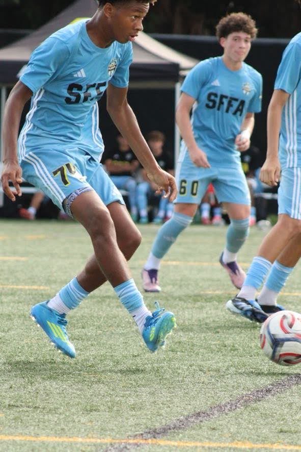 Chaz L. Grey, #74, dribbling at speed with teammates trailing the play