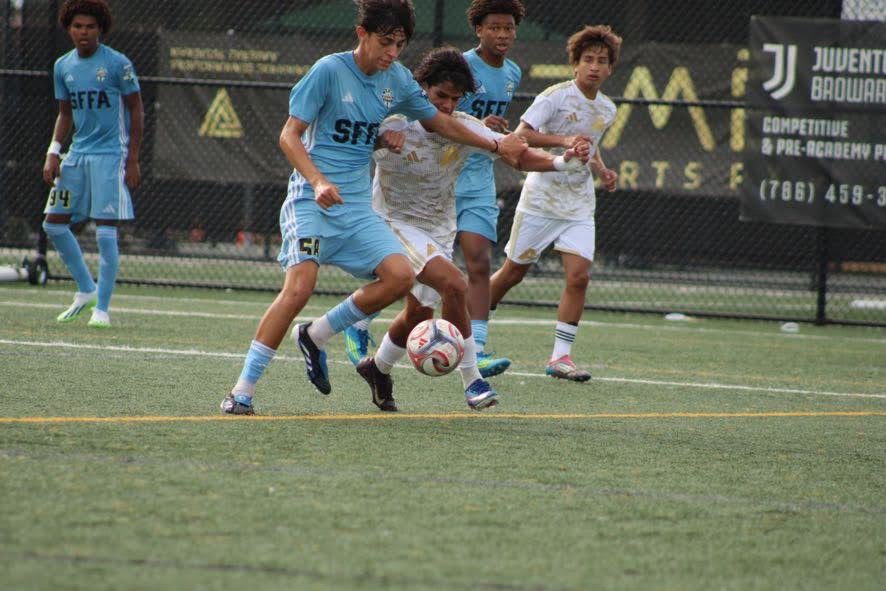 Chaz L. Grey contesting the ball in a crowd of players during a match